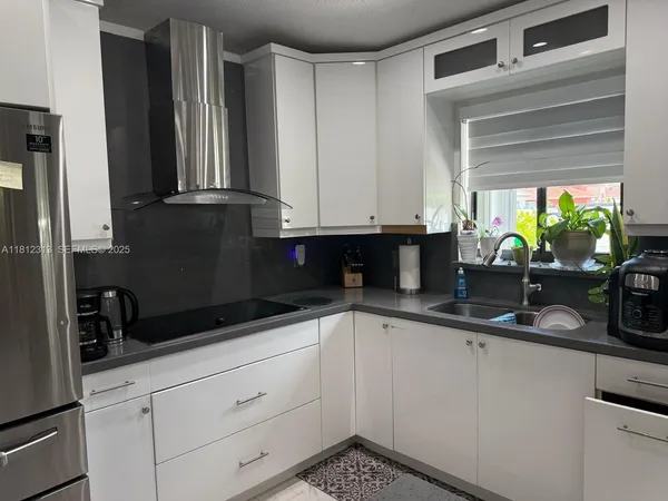 a kitchen with granite countertop a sink a stove and cabinets