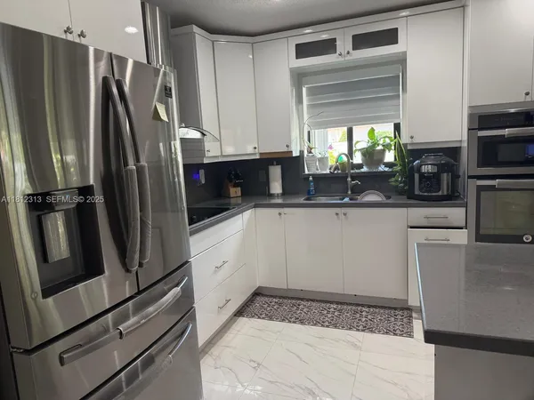 a kitchen with stainless steel appliances a refrigerator sink and microwave