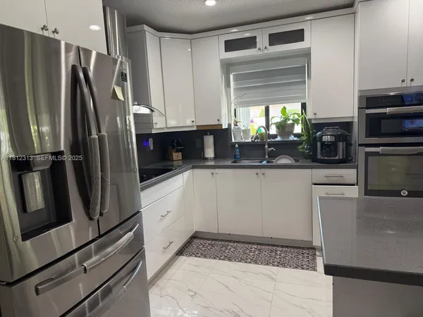 a kitchen with a refrigerator and a sink