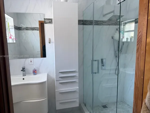 a bathroom with a shower sink and mirror