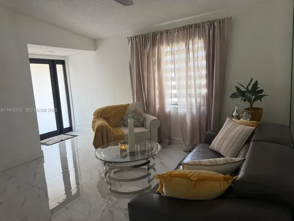 a living room with furniture and a potted plant