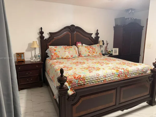 a bed sitting in a bedroom and dresser