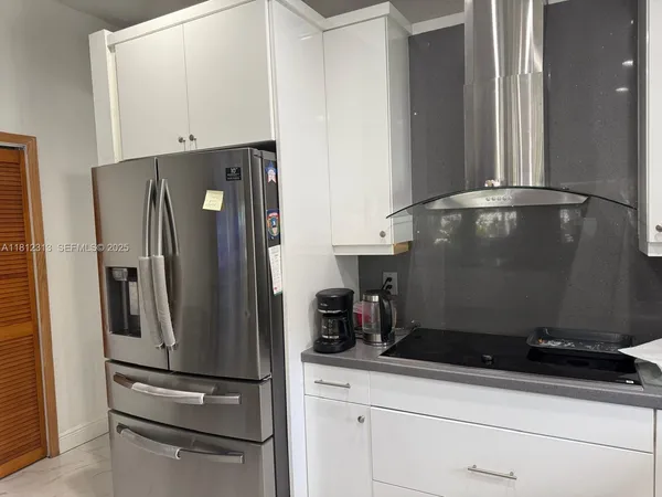 a close view of a refrigerator in kitchen and stainless steel appliances wooden floor