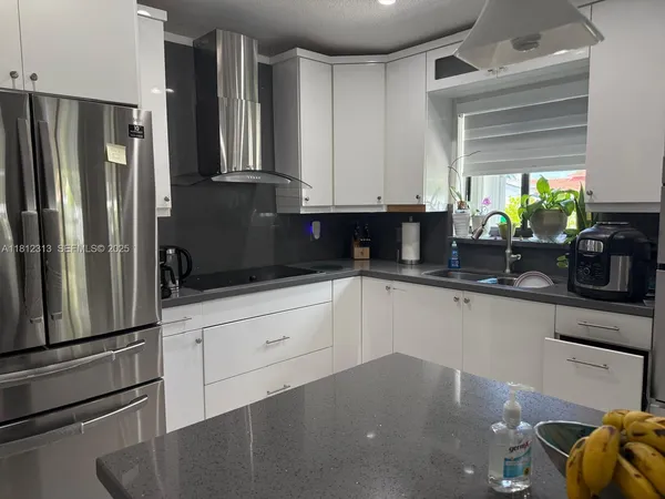 a kitchen with stainless steel appliances a refrigerator sink and cabinets