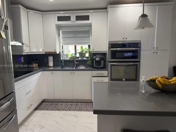 a kitchen with stainless steel appliances kitchen island granite countertop a sink and a stove