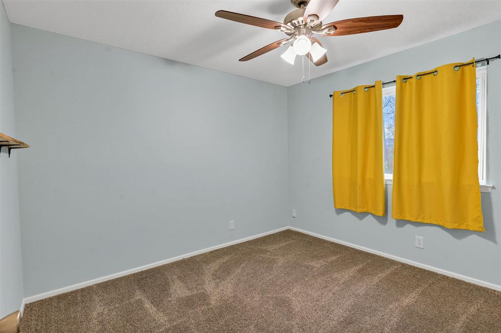 1009 Russell Road Everman, TX 76140 - Photo 15 of 20 an empty room with windows and chandelier fan