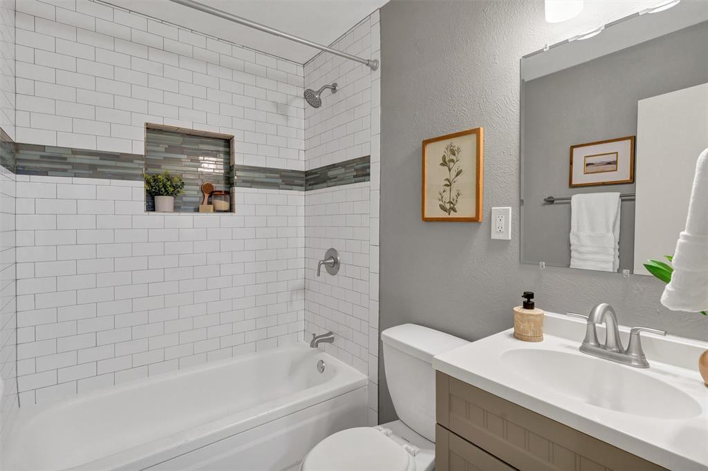 1009 Russell Road Everman, TX 76140 - Photo 16 of 20 a bathroom with a granite countertop sink a toilet and bathtub