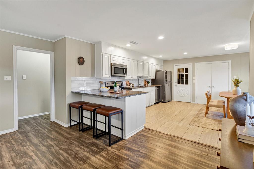 1009 Russell Road Everman, TX 76140 - Photo 6 of 20 a kitchen view with stainless steel appliances granite countertop a stove and a refrigerator