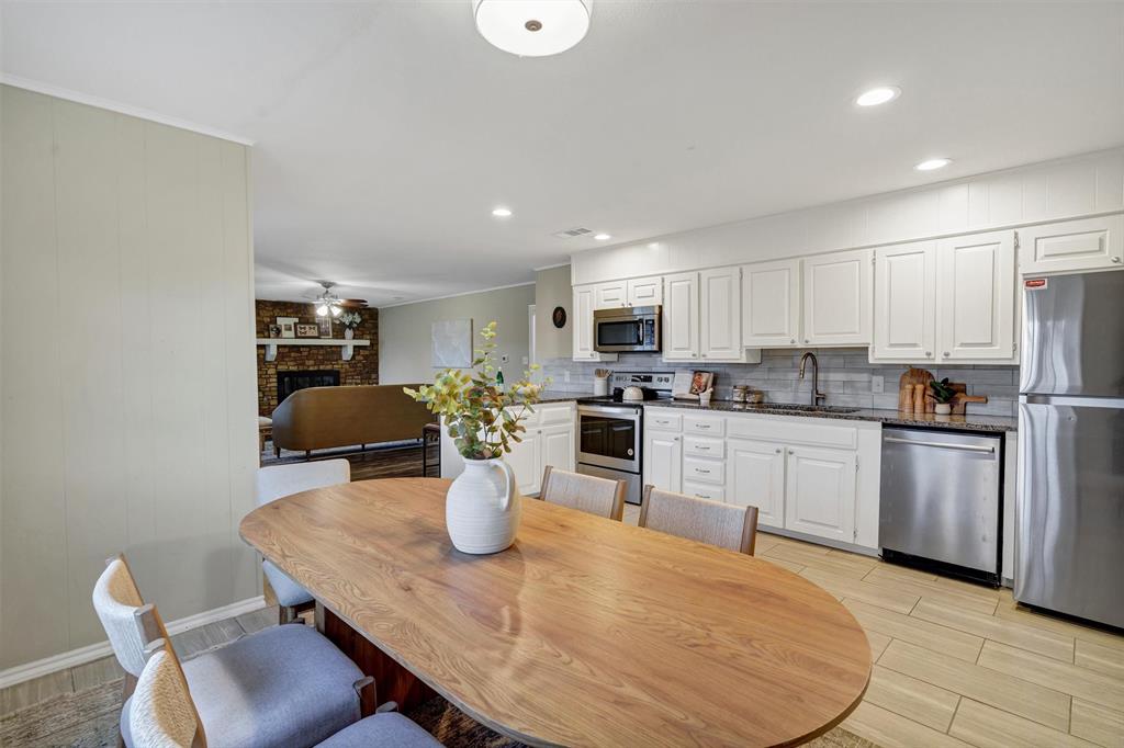 1009 Russell Road Everman, TX 76140 - Photo 10 of 20 a kitchen with a dining table chairs and refrigerator