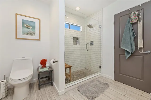 a bathroom with a sink a toilet a mirror and shower