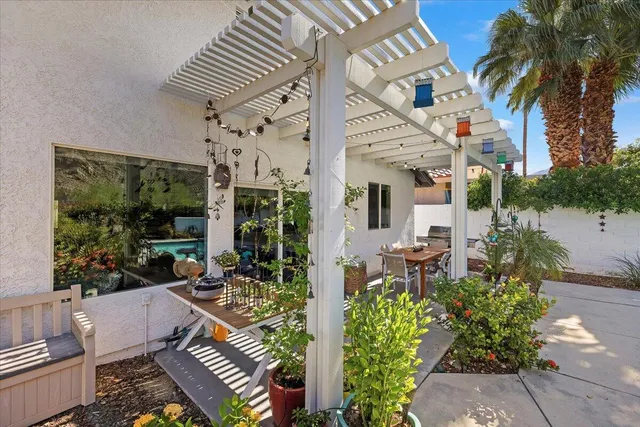 a view of a patio with couches table and chairs potted plants and palm tree