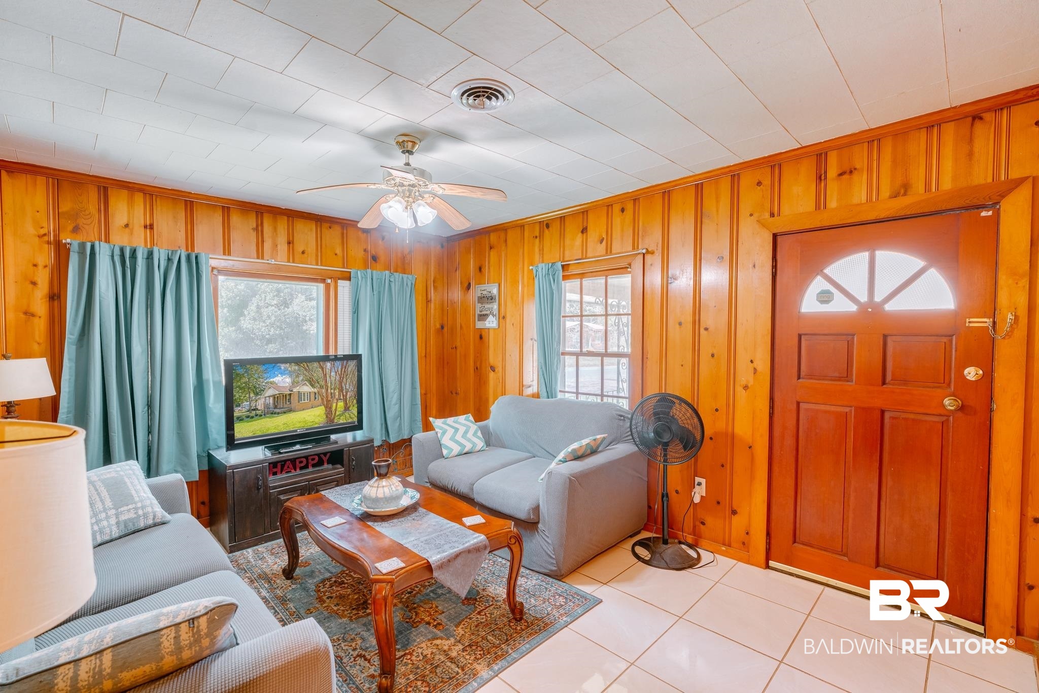 315 Fourth Avenue Chickasaw, AL 36611 - Photo 16 of 28 Living area with a ceiling fan, tile patterned flooring, wood walls, and visible vents