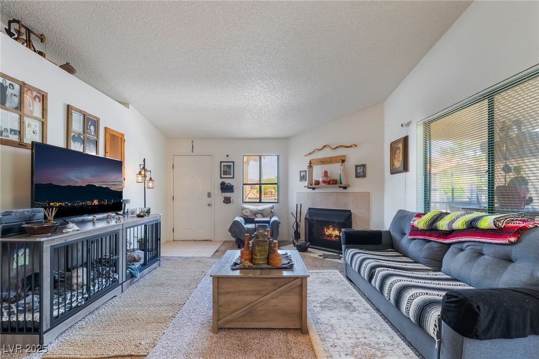 1575 West Warm Springs Road, Unit 2822 Henderson, NV 89014 - Photo 12 of 37 Carpeted living room featuring a textured ceiling and a tiled fireplace