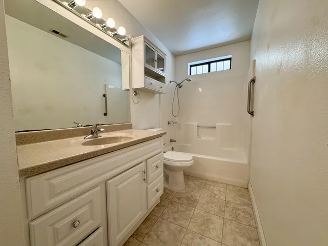 a bathroom with a granite countertop sink toilet a shower and a mirror