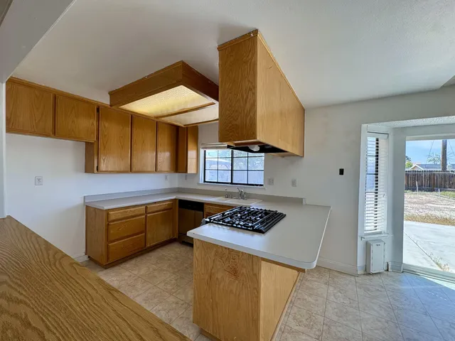 a kitchen with stainless steel appliances granite countertop a stove a sink dishwasher and cabinets with wooden floor