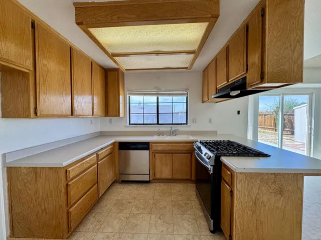 a kitchen with stainless steel appliances granite countertop a stove a sink and a microwave