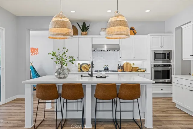 a kitchen with a table chairs sink and cabinets