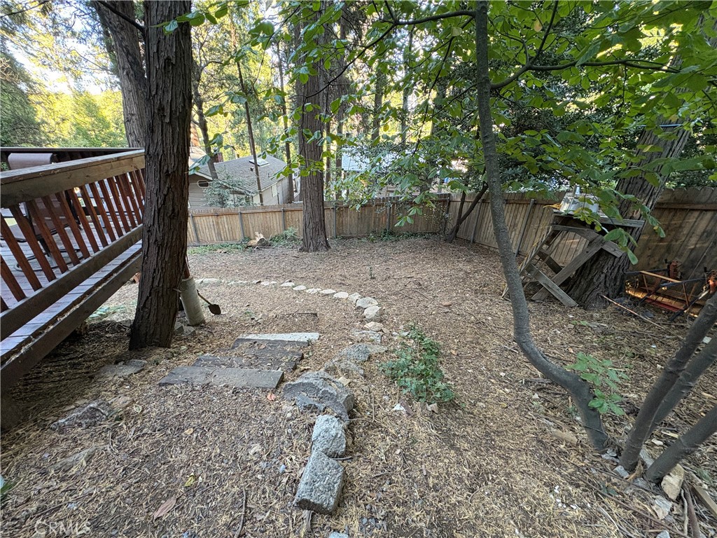 743 Woodland Road Crestline, CA 92325 - Photo 11 of 57 a view of a yard with wooden fence and a large tree