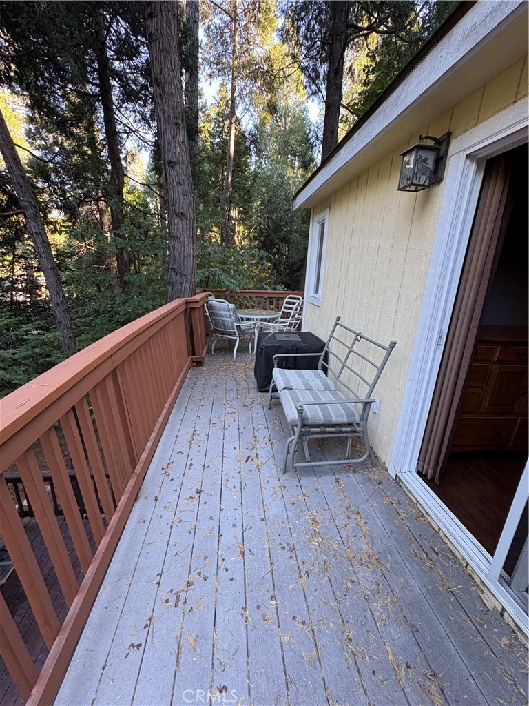 743 Woodland Road Crestline, CA 92325 - Photo 14 of 57 a balcony with wooden floor and outdoor seating