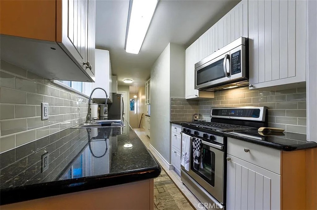 743 Woodland Road Crestline, CA 92325 - Photo 18 of 57 a kitchen with stainless steel appliances granite countertop a sink a stove microwave and cabinets
