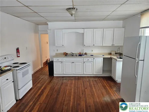 a kitchen with wooden floors and white appliances