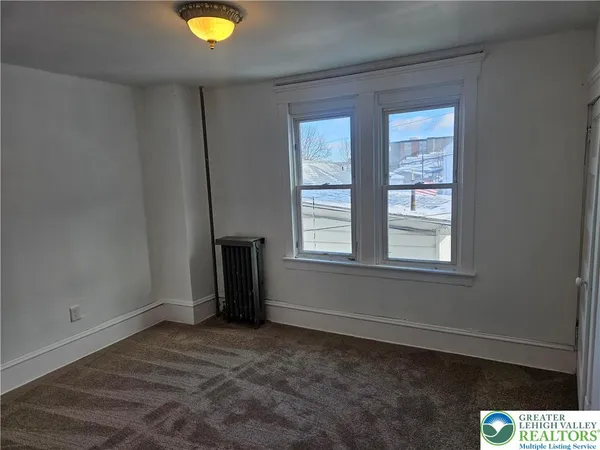 an empty room with windows and closet