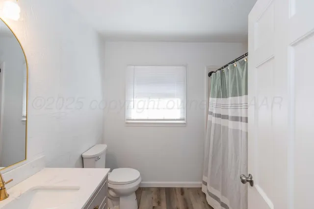 a white toilet sitting next to a bathroom sink and vanity