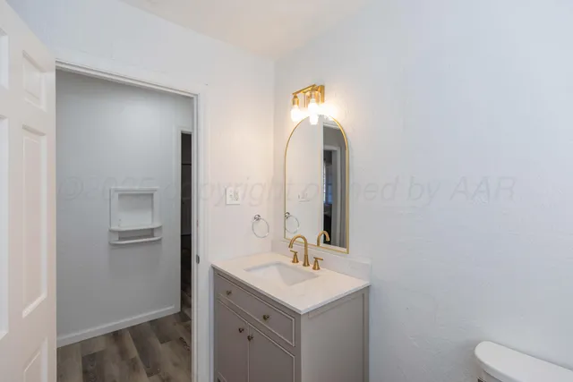 a bathroom with a toilet sink and mirror
