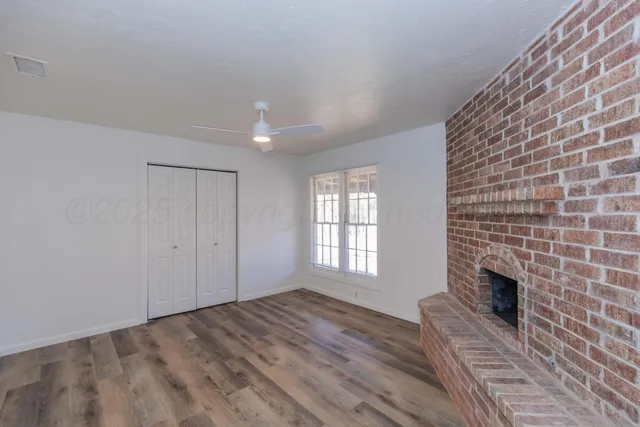 a view of an empty room with a fireplace and a window