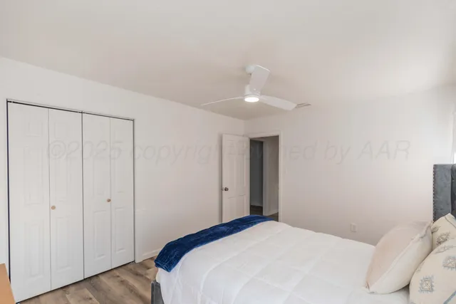 a bedroom with a bed and a ceiling fan