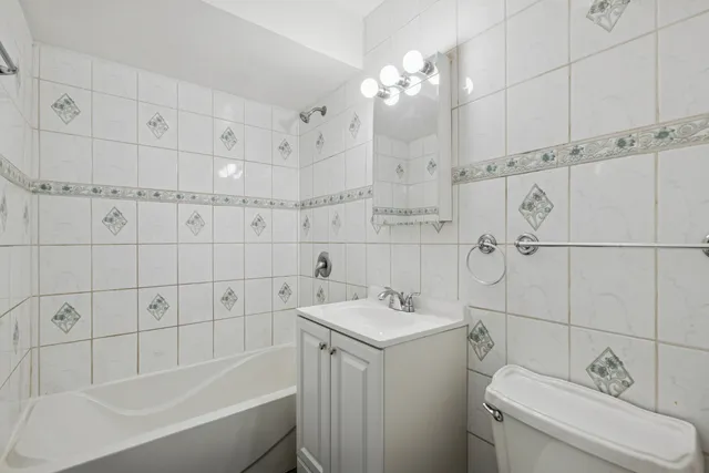 a bathroom with a sink vanity granite toilet and shower