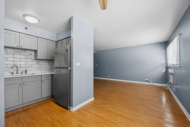 a view of a kitchen with a sink dishwasher a refrigerator and wooden cabinets