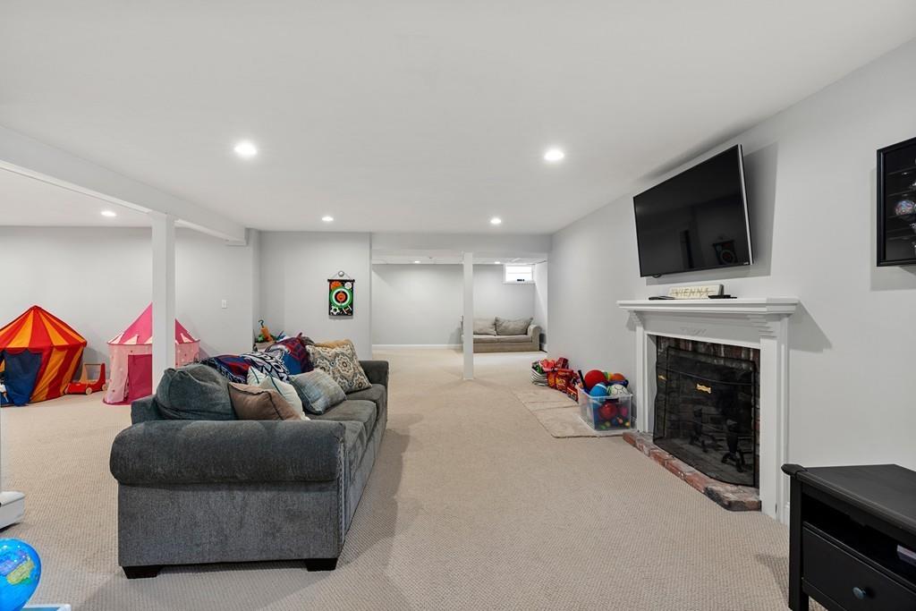 16 Standish Road Wayland, MA 01778 - Photo 20 of 22 a living room with fireplace furniture and a flat screen tv