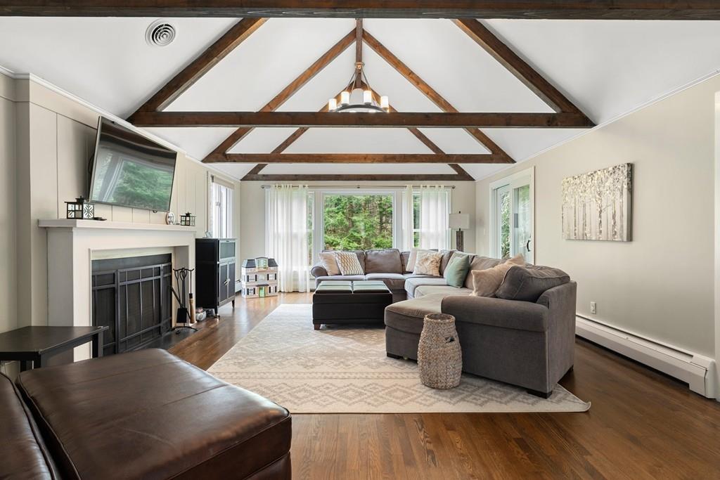 16 Standish Road Wayland, MA 01778 - Photo 4 of 22 a living room with furniture a fireplace and a floor to ceiling window