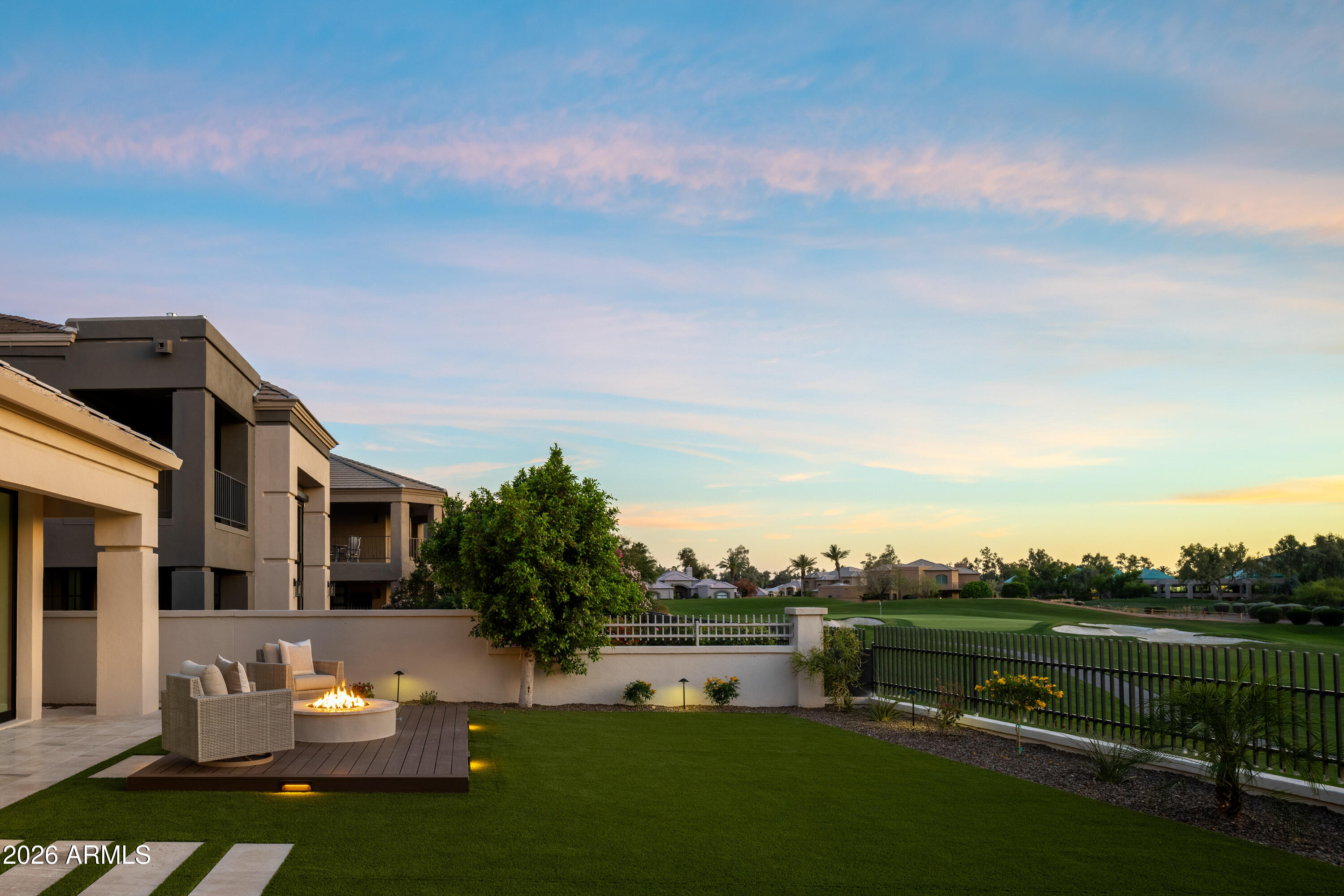 7878 East Gainey Ranch Road, Unit 14 Scottsdale, AZ 85258 - Photo 35 of 40 a view of a white house in front of a big yard with plants and large tree