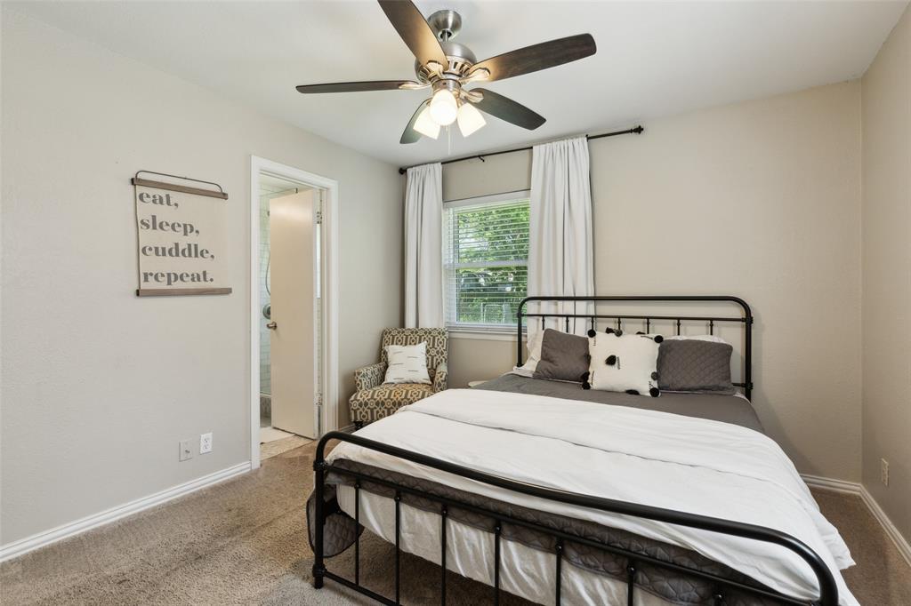 1202 Johns Drive Euless, TX 76039 - Photo 14 of 26 a bedroom with a bed and a chandelier