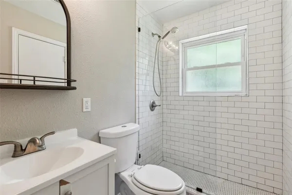 a bathroom with a sink a toilet and a mirror