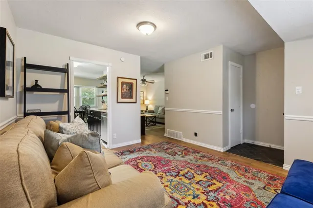 a living room with a couch and a dresser with wooden floor