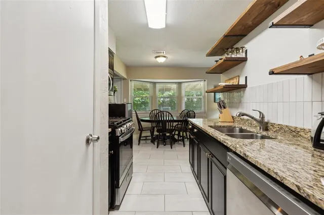 a kitchen with granite countertop sink stove and cabinets