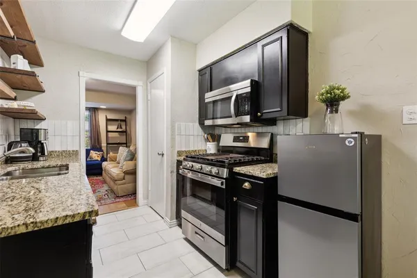 a kitchen with stainless steel appliances granite countertop a refrigerator stove and oven