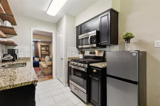 a kitchen with stainless steel appliances granite countertop a refrigerator stove and oven