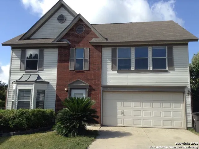 a house that has a large window and potted plants