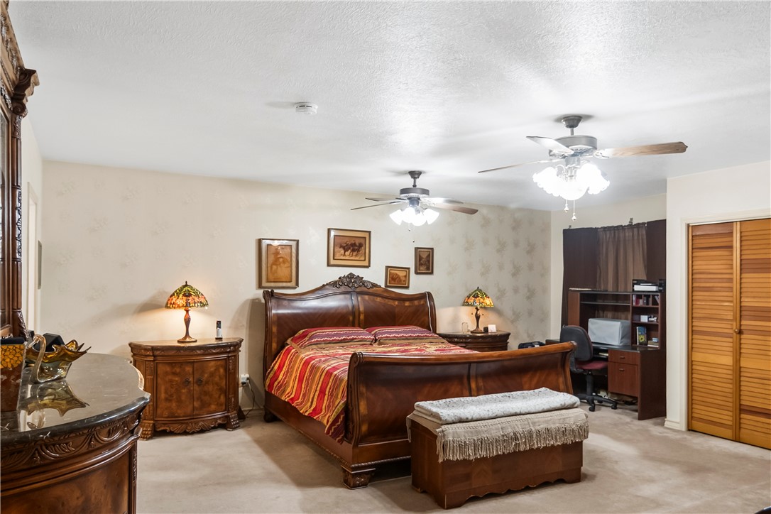 155 Harbor Circle Mathis, TX 78368 - Photo 24 of 40 a bedroom with a bed and wooden ceiling fan