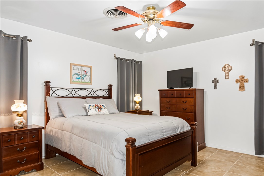 155 Harbor Circle Mathis, TX 78368 - Photo 28 of 40 a bedroom with a bed and a chandelier