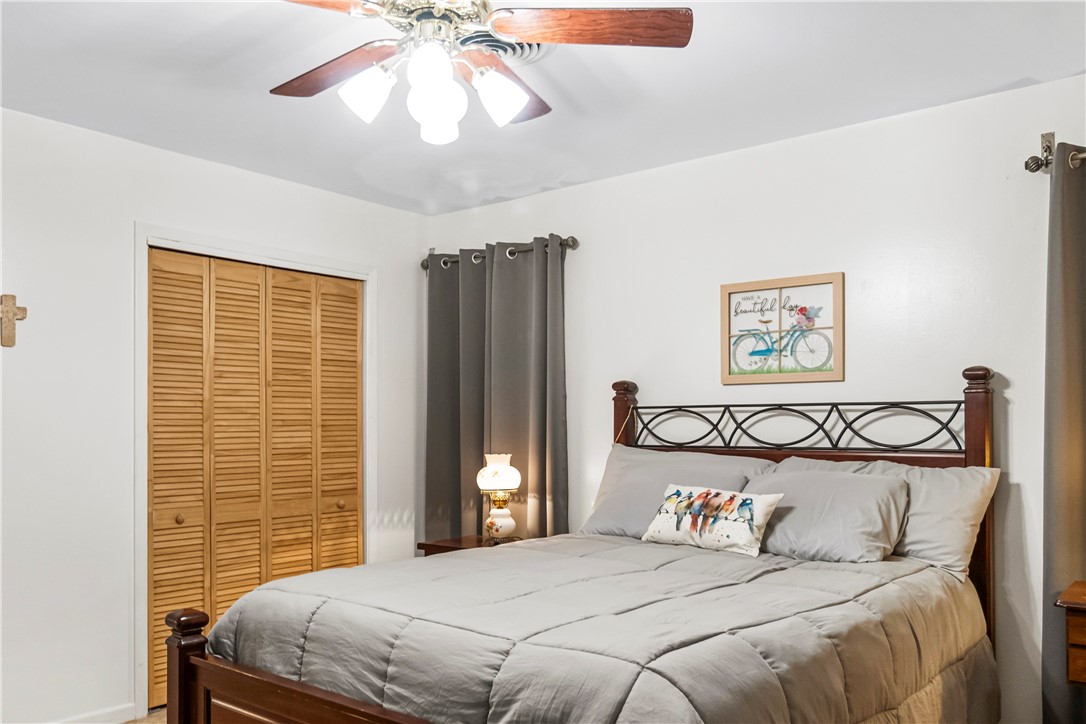 155 Harbor Circle Mathis, TX 78368 - Photo 29 of 40 a bedroom with a large bed and a chandelier