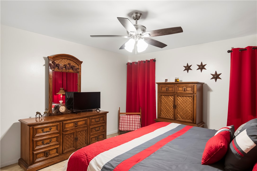 155 Harbor Circle Mathis, TX 78368 - Photo 34 of 40 a bedroom with a bed and a flat tv screen on dresser