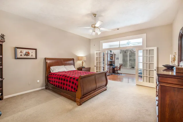 a spacious bedroom with a large bed and a chandelier
