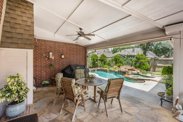 a patio with table and chairs and potted plants