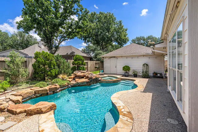 a view of a house with backyard sitting area and swimming pool