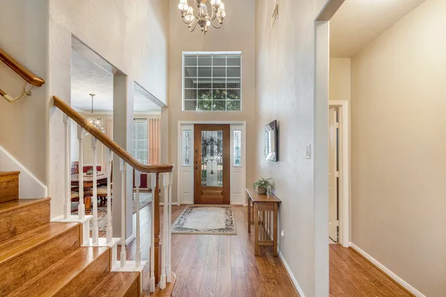 a view of a hallway with wooden floor and staircase